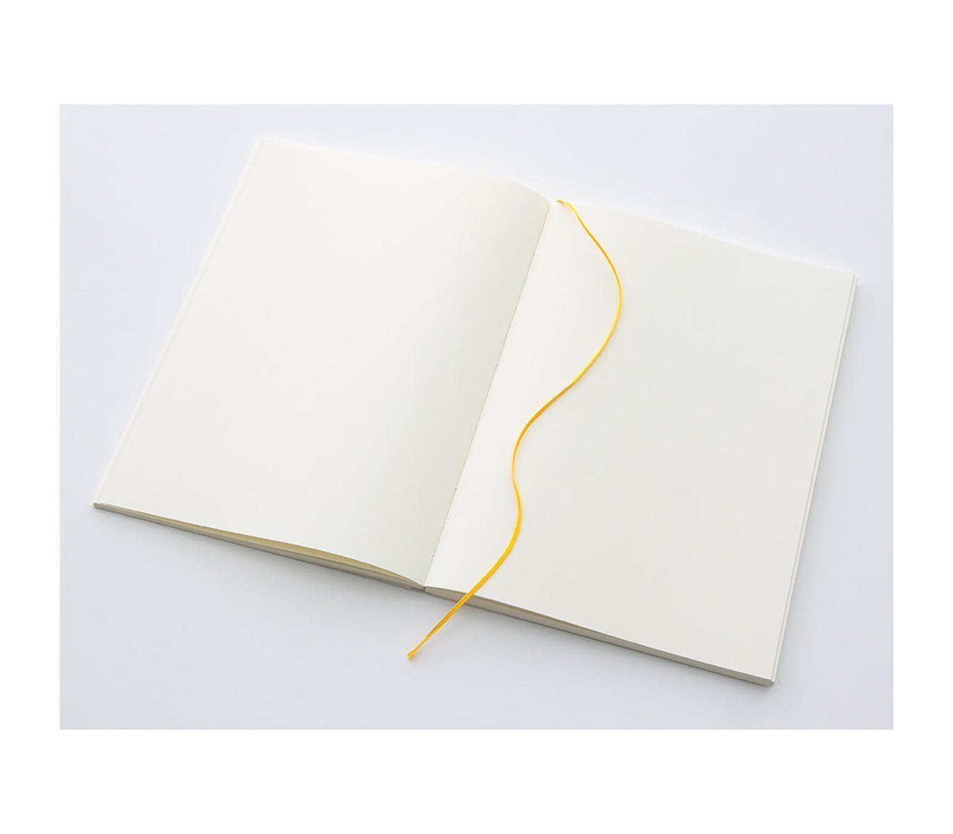 Midori MD notebook A5 Plain. Shows stickers. Yellow silk string. Notebook for journaling, note taking and sketching.