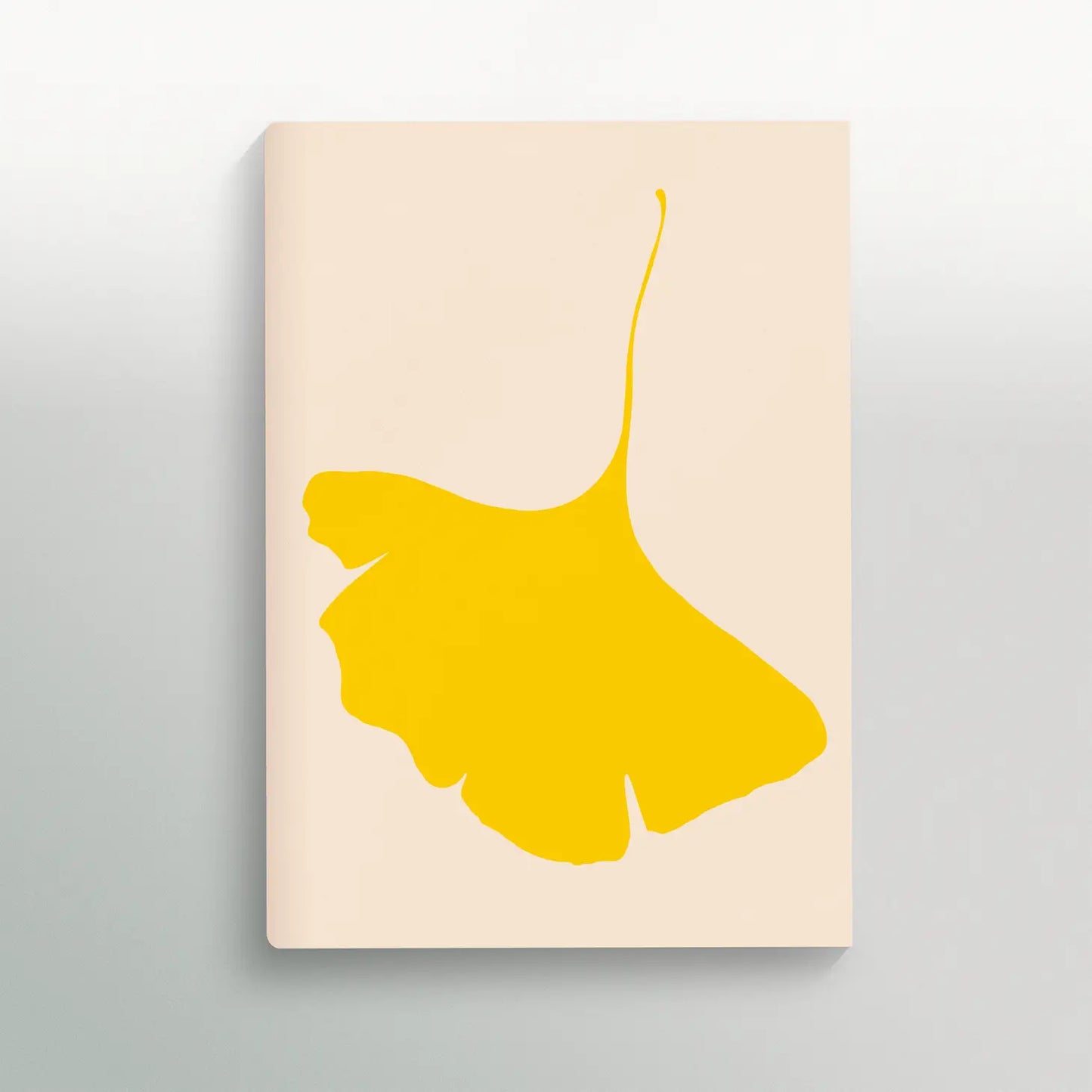 Notebook cover with pale beige as background and a bright yellow ginkco leafe turned upside down.